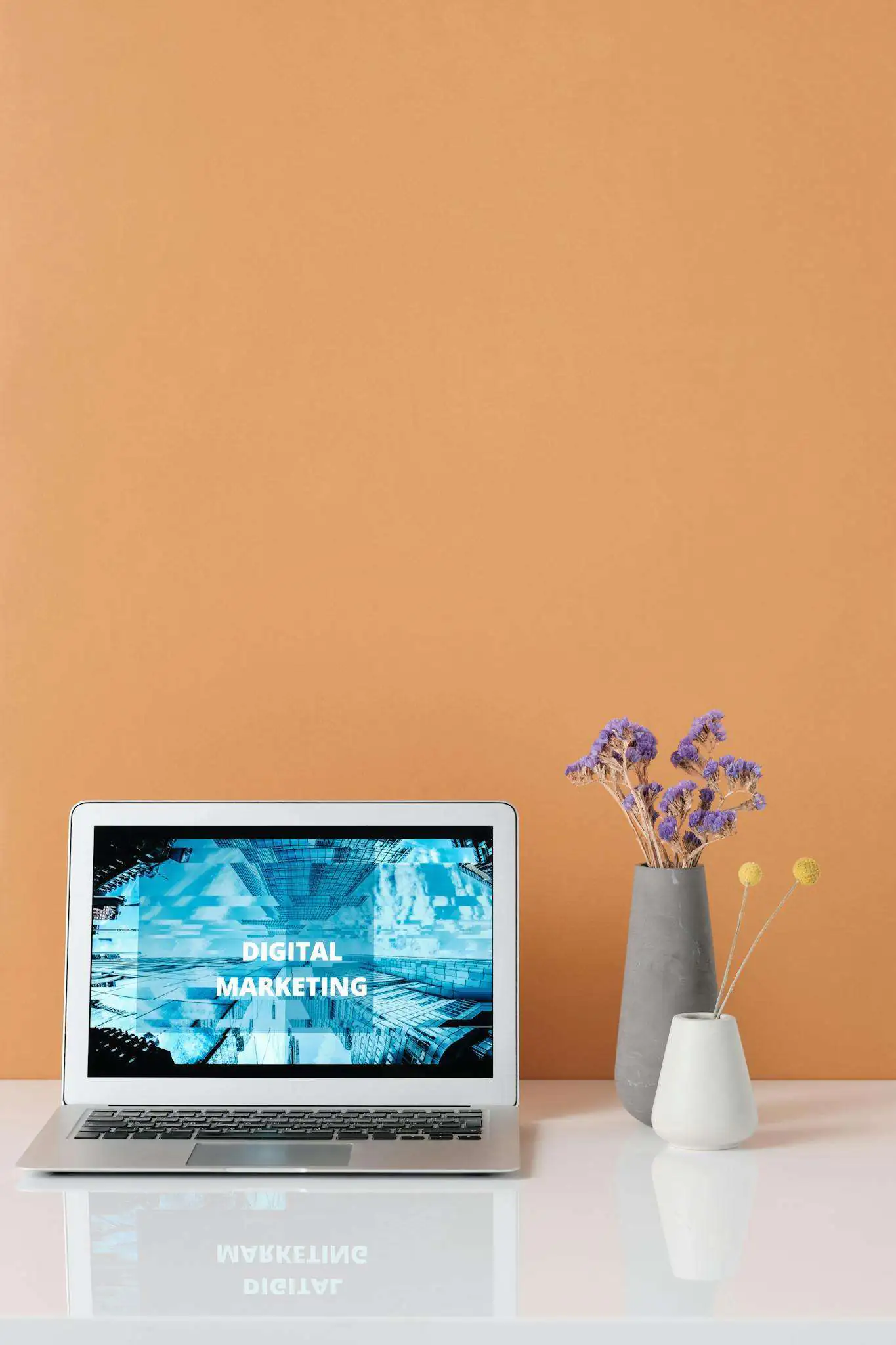 Modern workspace with laptop and decorative flowers showcasing digital marketing.